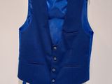 a blue vest on a hanger on a white wall