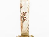 a tall glass vase with a bird design on it