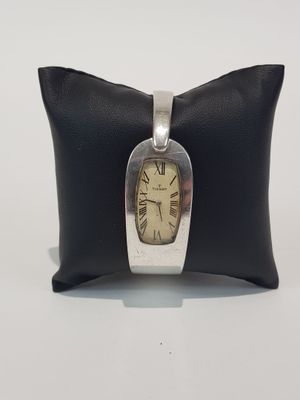 wrist watch sitting on a pillow on a white surface