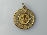 a gold coin with a crown on it sitting on a white surface