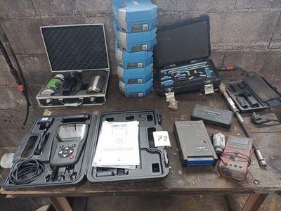 a table with a laptop, a monitor, and other electronic equipment on it