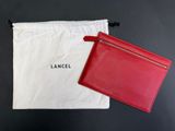 un sac rouge et blanc et un portefeuille rouge posés sur une table