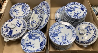 Des boîtes contenant des assiettes en porcelaine bleues et blanches sont empilées les unes sur les autres