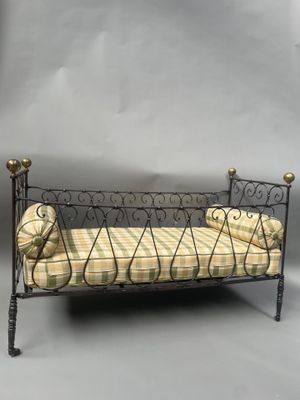 un panier pour chien posé sur un lit en métal