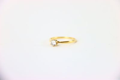une bague en or surmontée d'un seul diamant