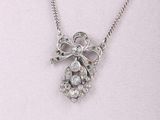 Collier plaqué argent orné d'un nœud et de cristaux sur fond blanc