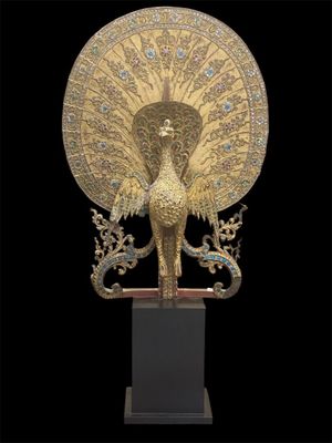 an image of a golden peacock statue on a black background