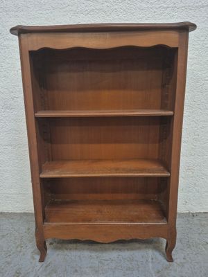 une vieille bibliothèque en bois surmontée de trois étagères