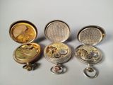 four different types of pocket watches sitting on top of a table