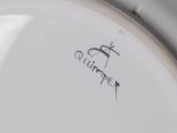 a close up of a white plate with a bird on it