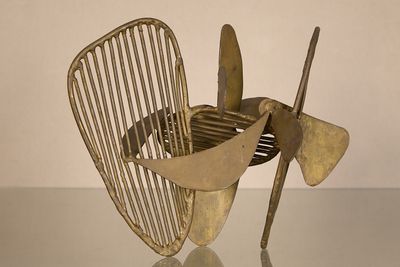 a metal sculpture of a propeller on a table