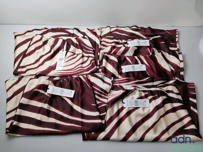 four brown and white zebra print pajama pants on a white surface