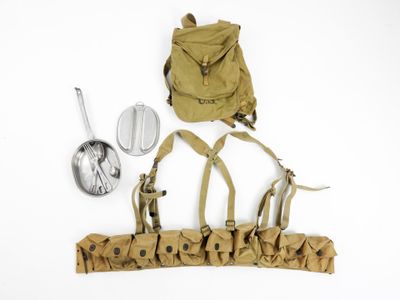 a backpack, a spoon, and other items laid out on a white surface