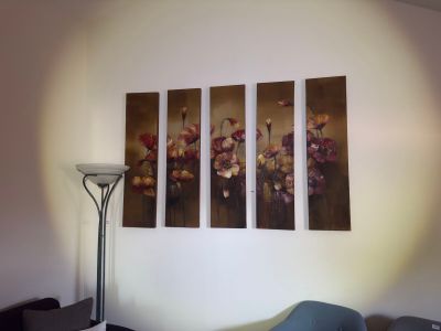 three paintings hanging on the wall above a bed