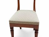 a wooden chair with a beige upholstered seat on a white background