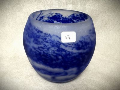 un vase bleu sur lequel est apposée une étiquette blanche