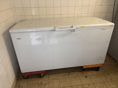 a small white chest freezer sitting in the corner of a room