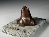 statue of a bear on a marble base on a white surface