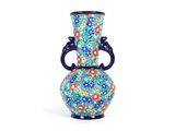 un vase muni d'une anse décorée de fleurs