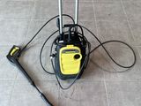 a yellow and black pressurer on the floor next to a black and yellow hose