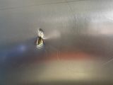 a bullet in the middle of a stainless steel surface