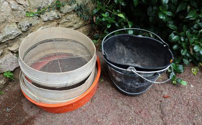 two buckets sitting next to each other on the ground