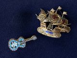 two brooches that are sitting on a blue surface