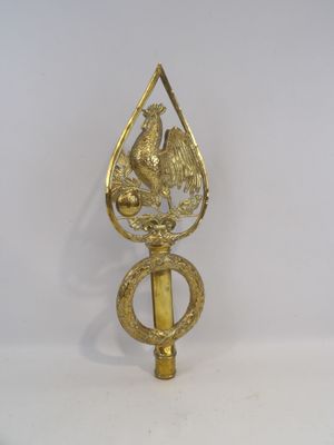 a gold bird on top of a brass object