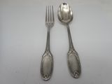 two spoons and a fork on a white table