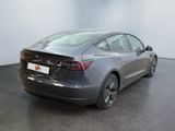 the back of a tesla model 3 parked in a showroom