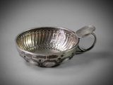 a silver bowl with a spoon in it on a table