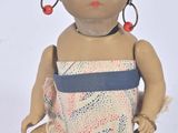 a small doll with a turban sitting on a white surface