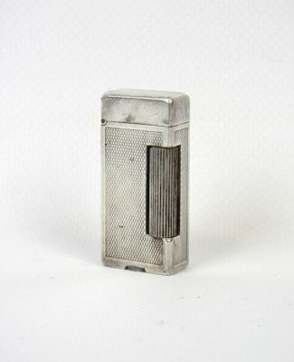 un briquet argenté posé sur une surface blanche