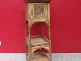 a small wooden shelf with a shelf on it in front of a red wall