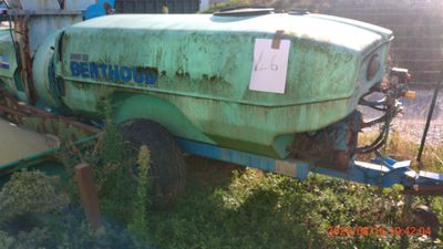 a tractor with a trailer attached to it in the grass