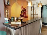 a bar in the middle of a room with a painting on the wall behind it