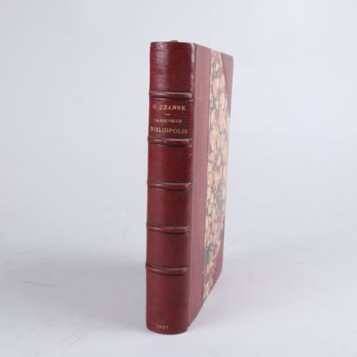 un vieux livre à la couverture rouge posé sur une surface blanche