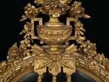 a mirror with a gold frame and a vase with flowers on it