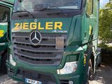 deux camions verts garés l'un à côté de l'autre sur un parking