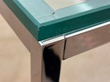 a close up of a glass table with a metal frame
