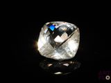 gros plan d'un diamant blanc sur une surface noire