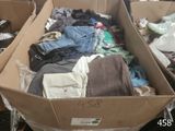 a cardboard box full of clothes sitting on the floor