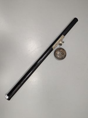 une image représentant une pipe en noir et blanc et une pièce de monnaie posées sur une surface blanche