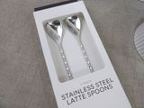 two silver spoons in a box on a table