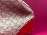 a close up of a purse on a pink surface