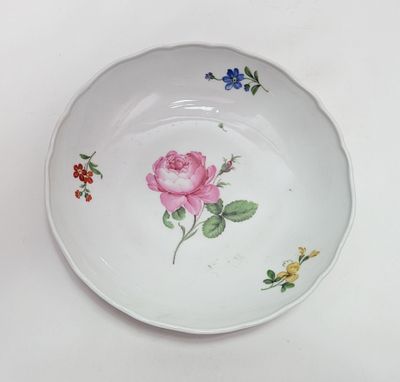 une assiette blanche sur laquelle est peinte une rose rose