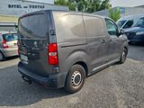 a grey van parked in a parking lot next to other cars