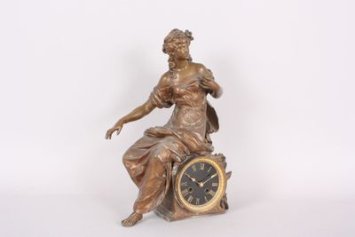 a statue of a woman sitting on top of a clock