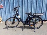 un vélo noir garé devant un mur bleu