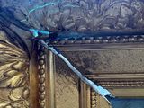 a gold frame with a blue ribbon hanging from it